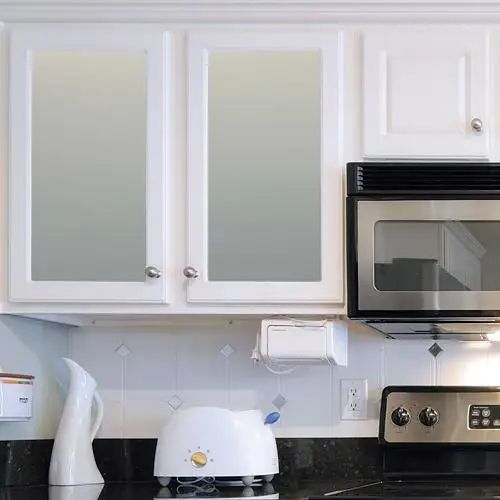 a microwave oven sitting on top of a counter next to a toaster and coffee maker