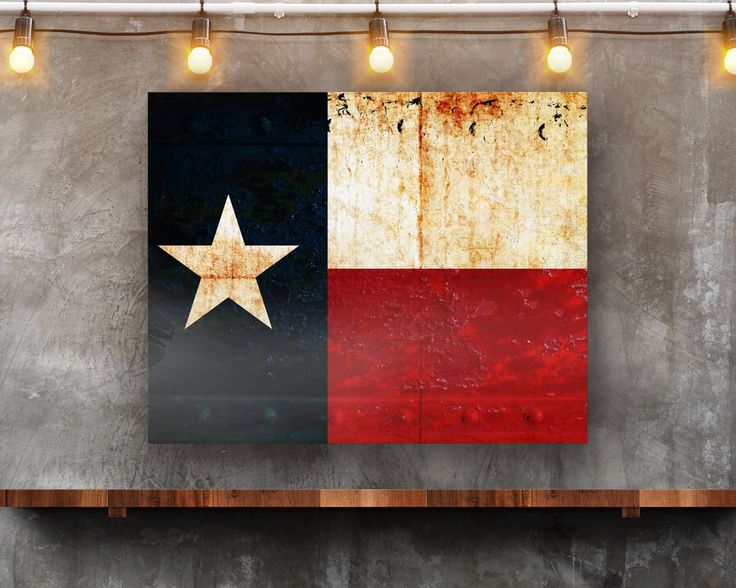 the texas state flag is displayed on an old concrete wall with lights hanging above it