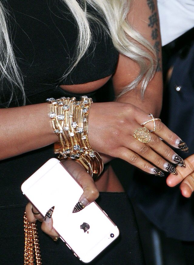 the woman is holding her cell phone in her hand and bracelets on her wrist