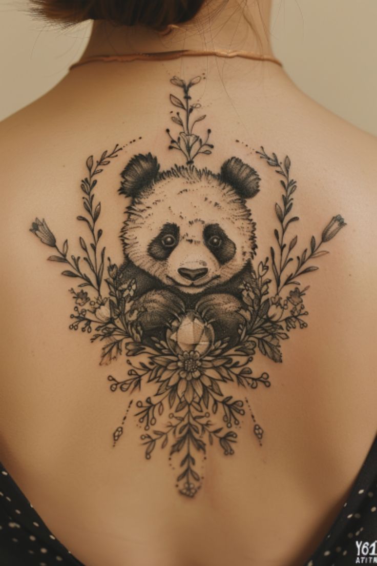 a woman's back with a panda bear tattoo on it