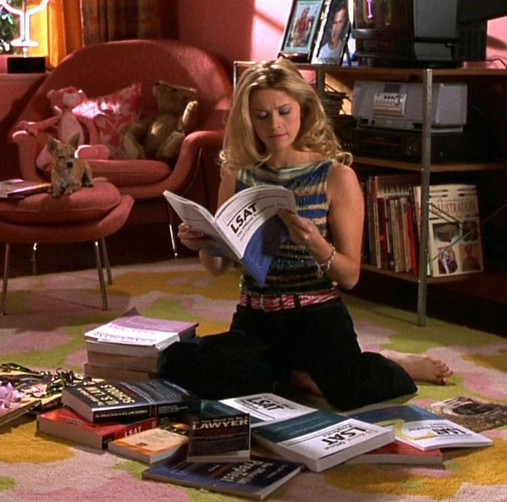 a woman sitting on the floor reading a book