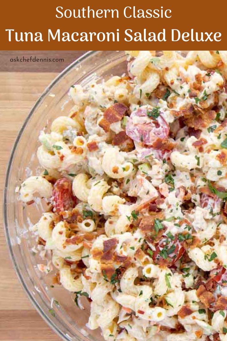 a bowl filled with macaroni salad on top of a wooden table