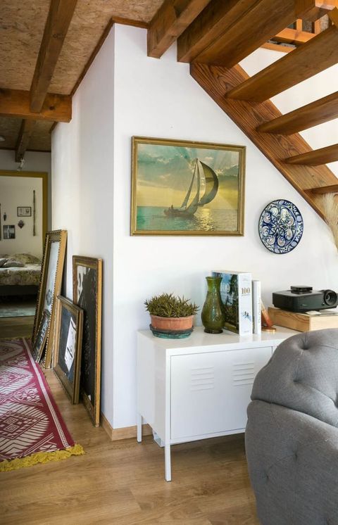 a living room filled with furniture and paintings on the wall