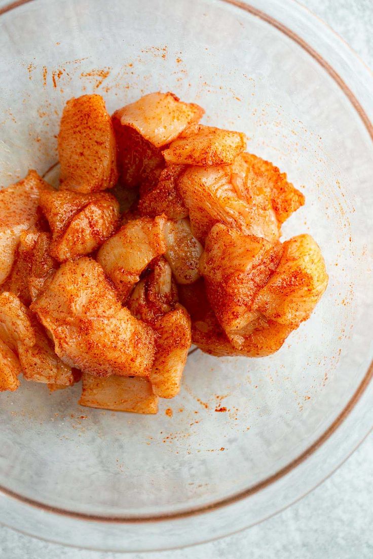 a glass bowl filled with fried food on top of a white tablecloth covered floor