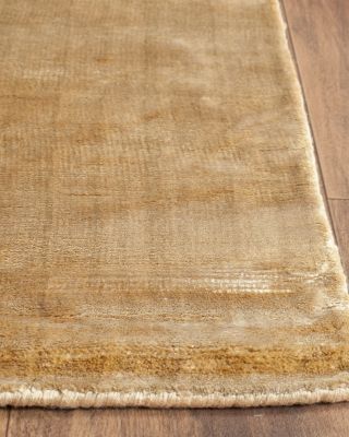 an area rug with wood flooring on top of it and a wooden floor in the background