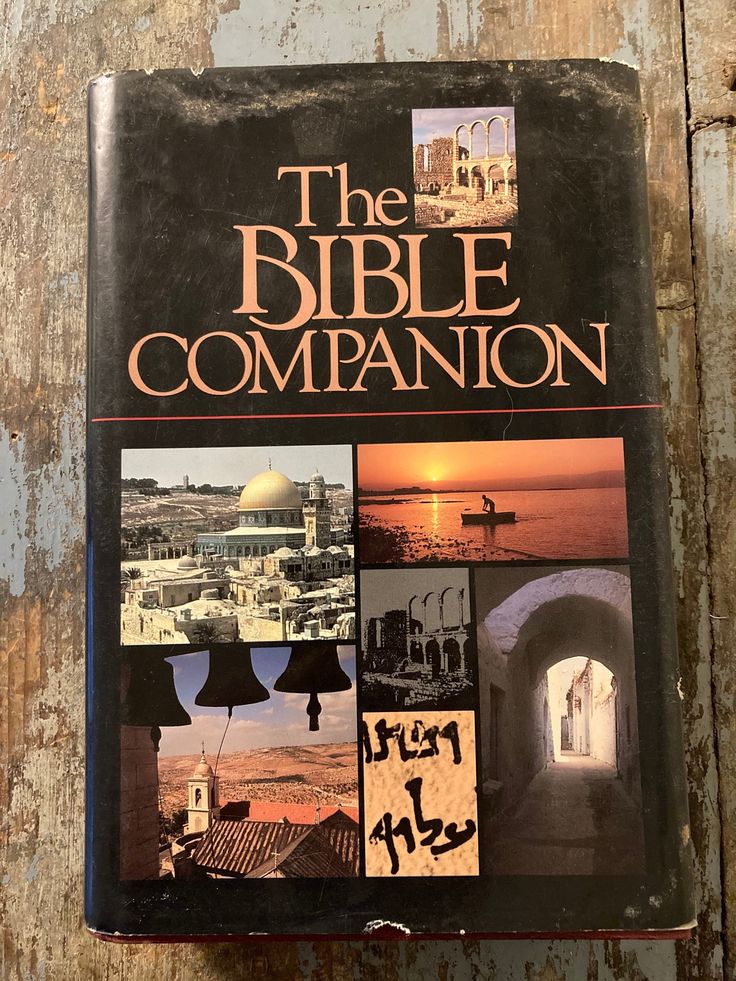 the bible companion book is sitting on a wooden surface