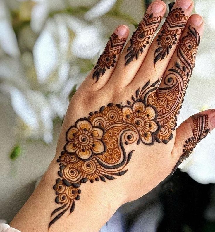 a woman's hand with henna tattoos on it