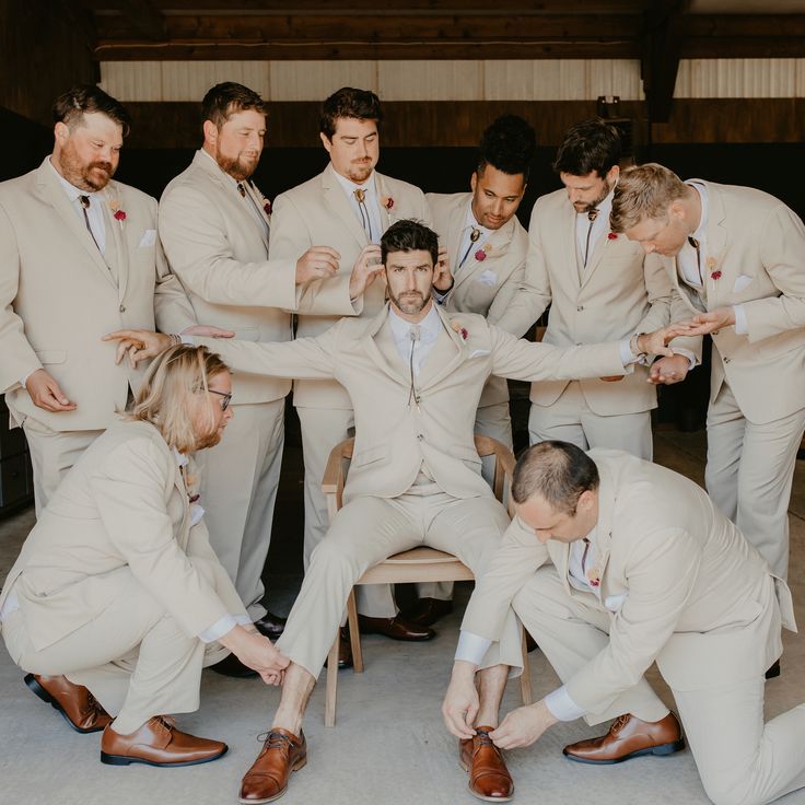 a group of men in suits and ties standing around each other with their hands together