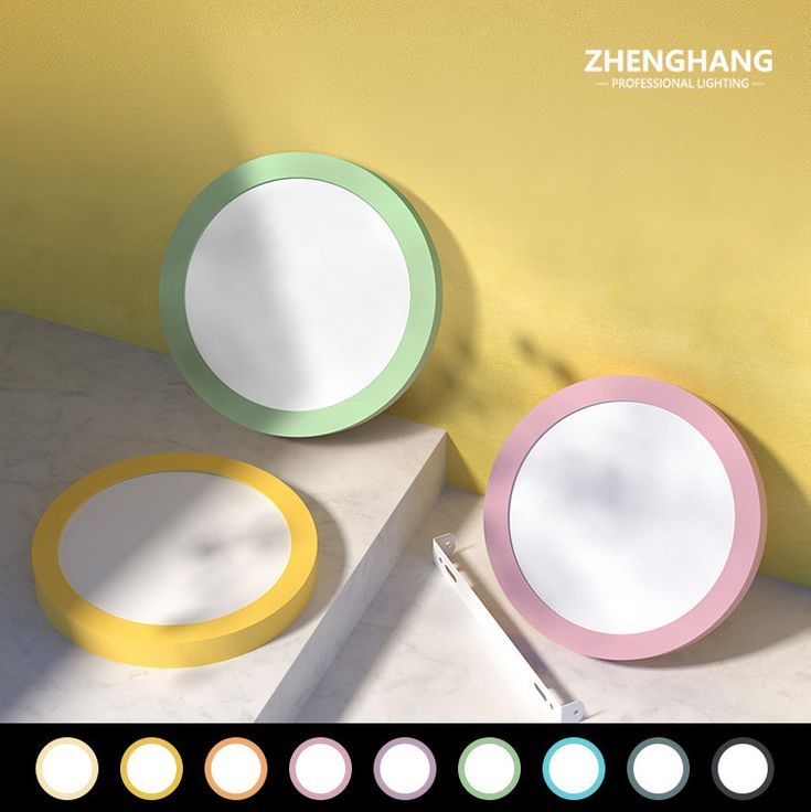 three circular mirrors sitting on top of a counter next to a wall with different colors