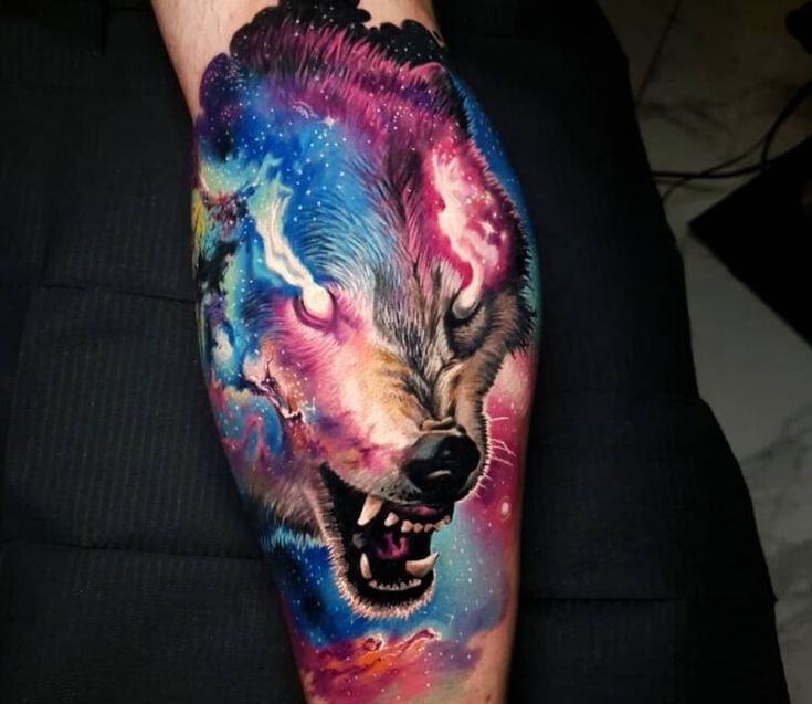 a man's arm with a colorful wolf tattoo on it