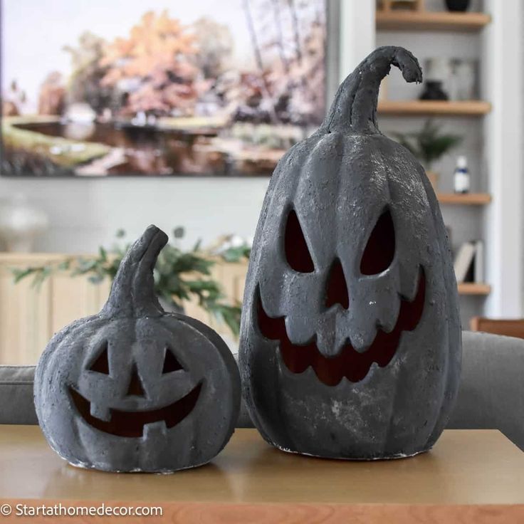 two carved pumpkins sitting on top of a table