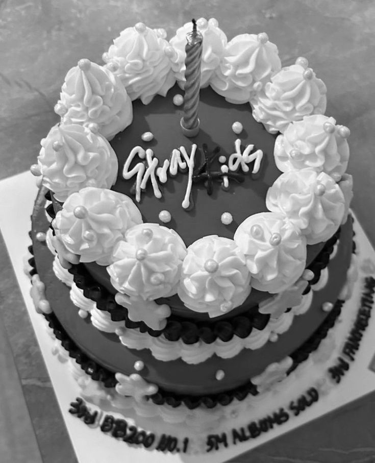 a black and white photo of a birthday cake with the word happy written on it