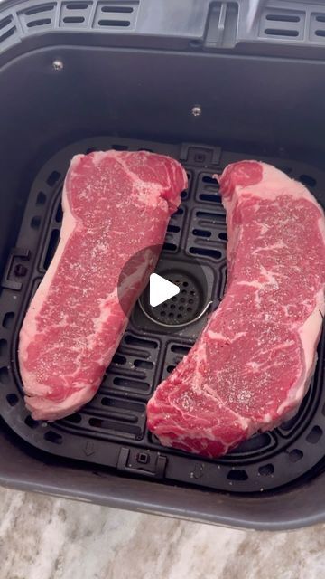 two raw steaks sit in an air fryer