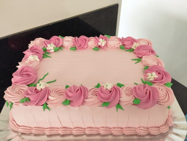 a pink frosted cake with flowers on it