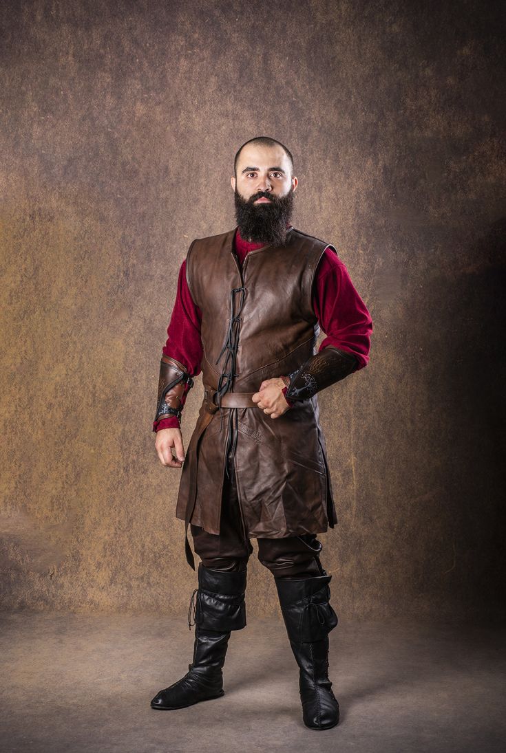 a man with a beard and leather outfit