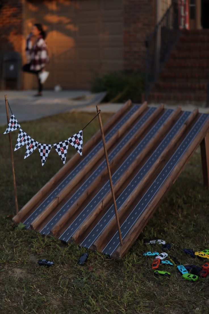 an upside down solar panel with two flags on it in the grass next to a house