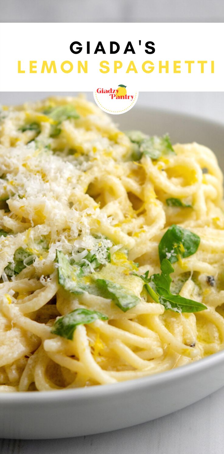 a white bowl filled with pasta and cheese on top of a table next to a fork