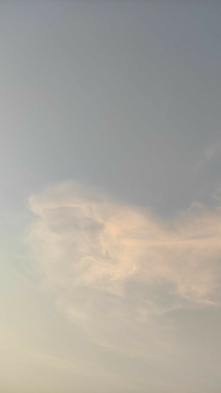 two people standing on the beach flying a kite in the sky over the water and sand