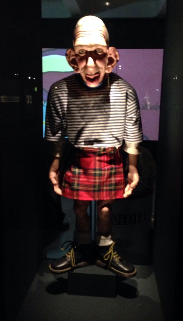 an old man dressed in a kilt and wearing glasses with his mouth wide open