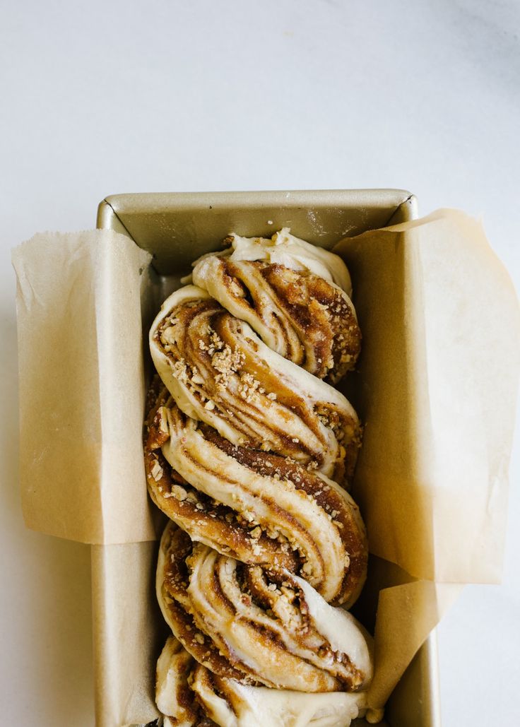 a box filled with cinnamon rolls covered in icing