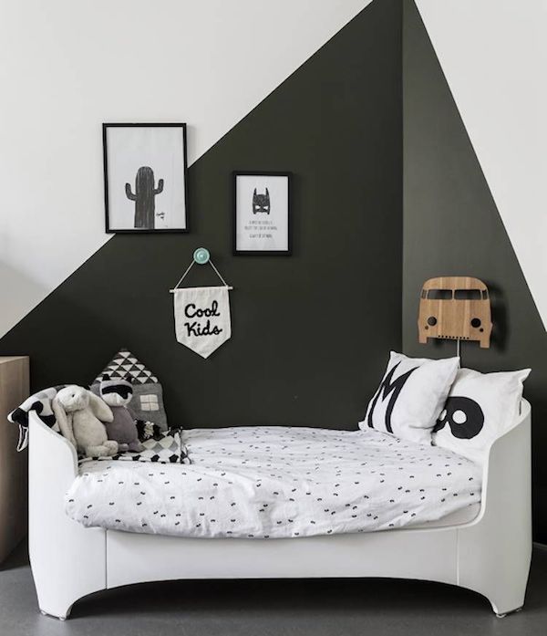 a white bed sitting in a bedroom next to a wall with black and white pictures on it