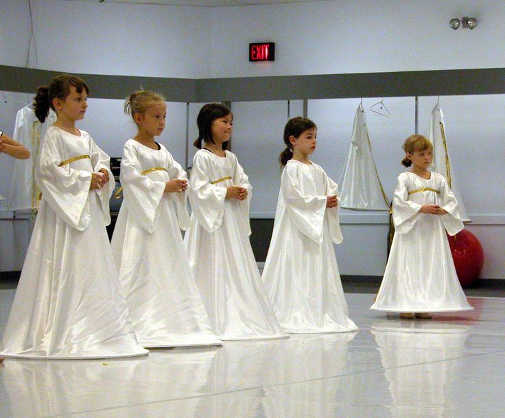 several children in white dresses are lined up