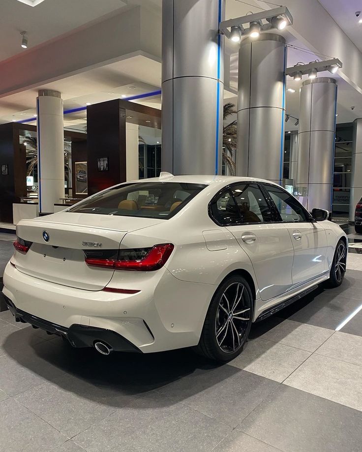 a white car is parked in a showroom