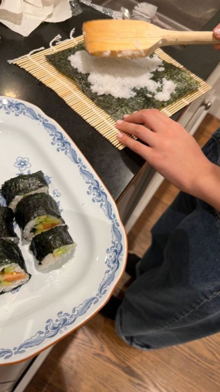 sushi being prepared on a plate with chopsticks