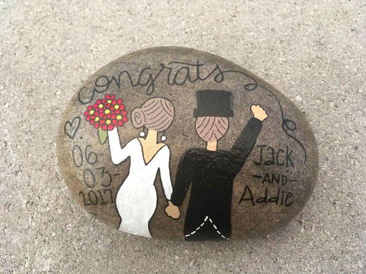 a painted rock with the words congrats and an image of two people holding flowers