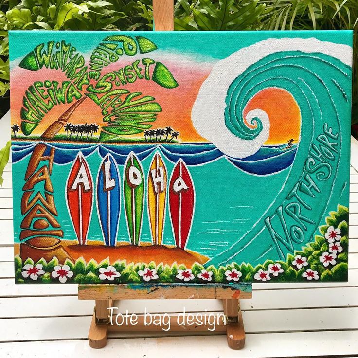 an easel painted with surfboards and the words aloha on it in front of some tropical plants