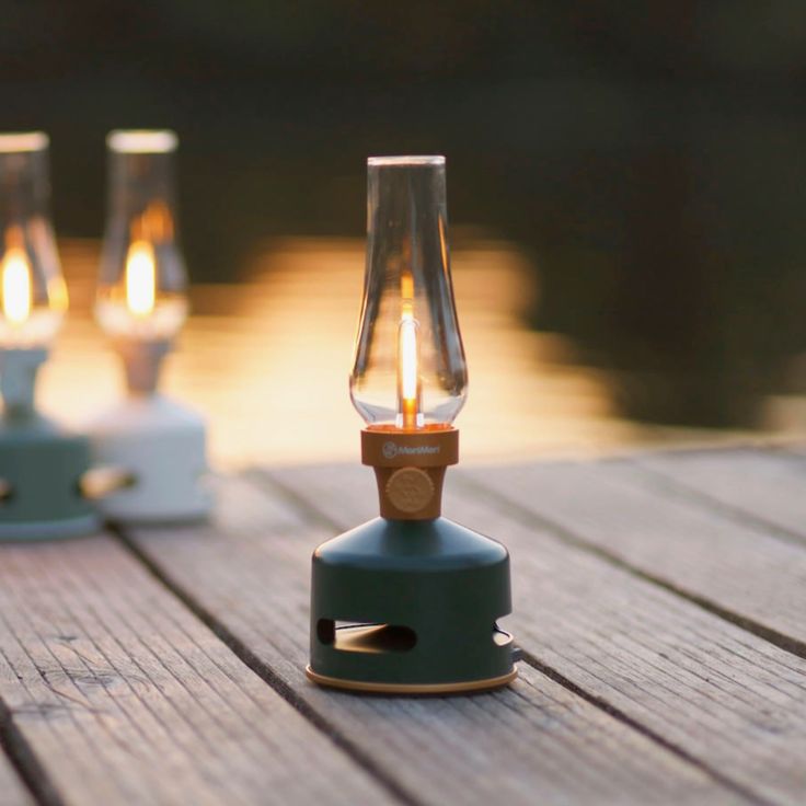 three small lights sitting on top of a wooden table next to each other, one with a light bulb in the middle