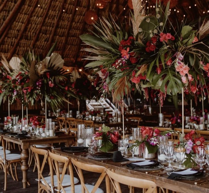 a table set up with flowers and greenery for an outdoor wedding reception at the lodge