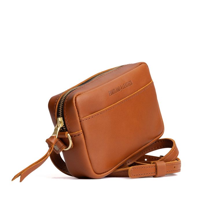 a tan leather bag with a zipper on the side