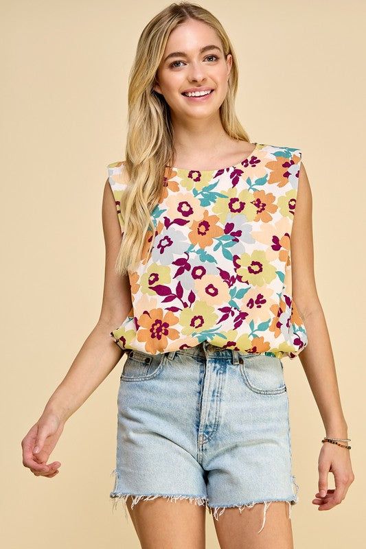 Sleeveless floral print top with elastic band at the bottom 100% Polyester Patterned Sleeveless Top With Floral Print, Patterned Floral Print Sleeveless Tops, Patterned Sleeveless Top For Spring, Sleeveless Patterned Top For Spring, Casual Multicolor Floral Print Tank Top, Spring Sleeveless Floral Print Tops, Floral Print Sleeveless Tops For Spring, Casual Multicolor Floral Tank Top, Sleeveless Floral Print Tops For Spring