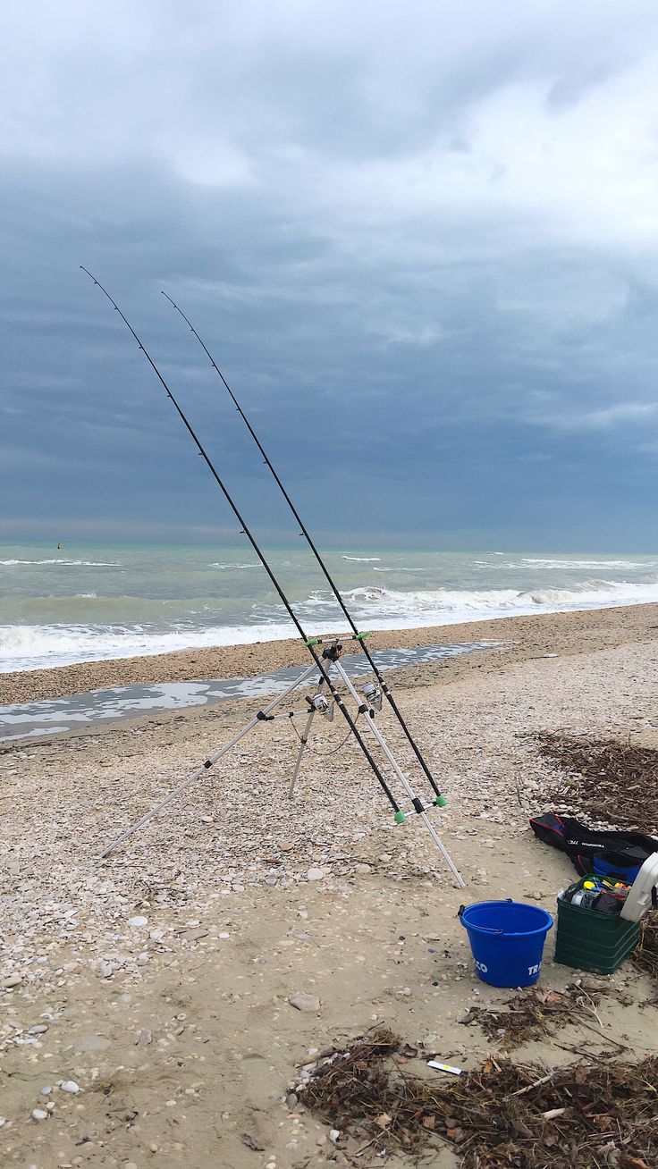 two fishing rods and buckets on the beach