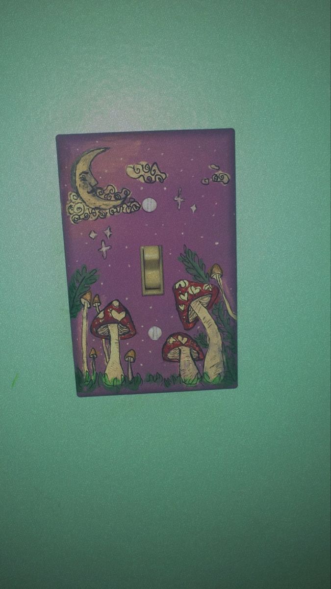 a purple light switch cover with mushrooms and stars on the night sky in front of a green wall