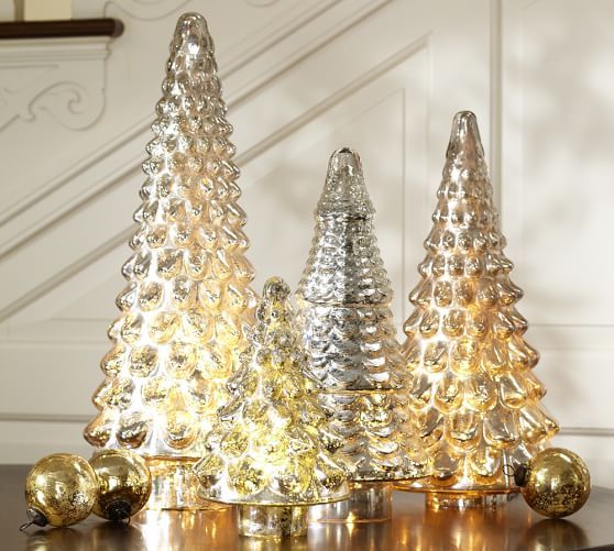 three glass christmas trees sitting on top of a table