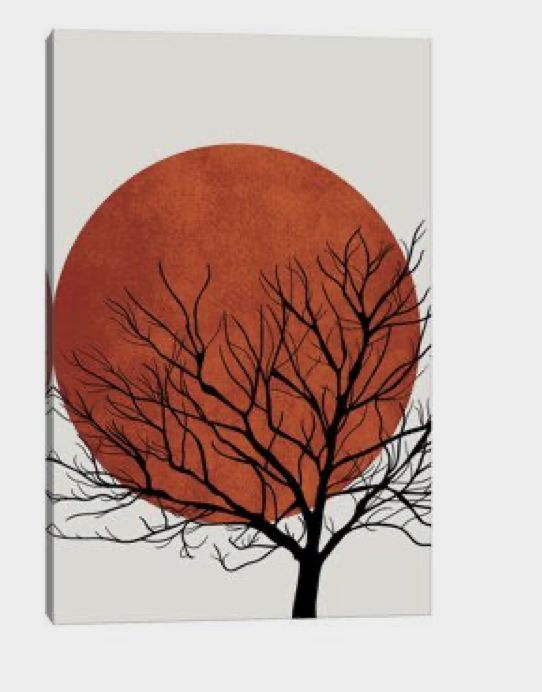 a tree with no leaves in front of a red sun