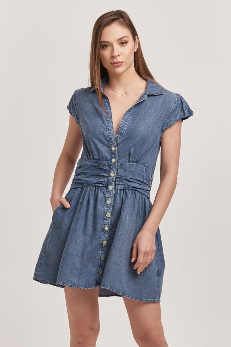 image of a female model wearing a SAWYER BUTTON DOWN DRESS INDEPENDENCE BLUE TENCEL DEAR JOHN DENIM Medium Wash Button-up Dress For Daywear, Short Sleeve Denim Dress With Button Closure For Daywear, Medium Wash Summer Dress With Buttoned Pockets, Fitted Summer Shirt Dress With Buttoned Pockets, Medium Wash Short Sleeve Shirt Dress With Buttons, Casual Cotton Cap Sleeve Dress, Fitted Button-up Midi Dress With Pockets, Short Sleeve Dresses With Buttoned Pockets For Work, Casual Cotton Dress With Cap Sleeves