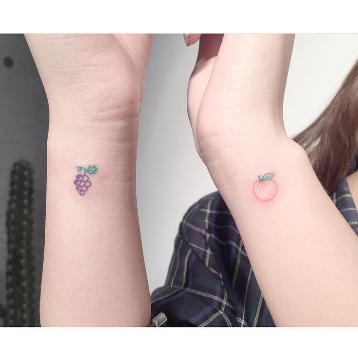 two people with matching tattoos on their arms and one has a small apple tattoo on the wrist