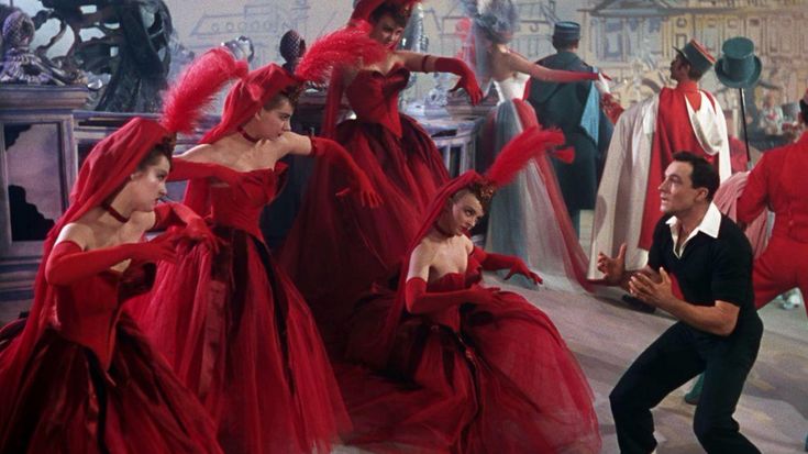 a group of people in red dresses dancing