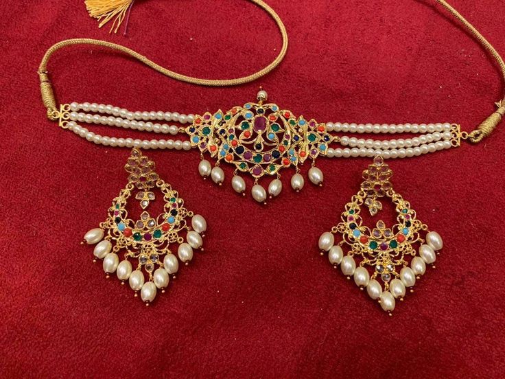 Delicately sized choker with semi precious navratan embedded jewels. Gold plated over silver. The set comes with matching earrings. Elegant Multicolor Jewelry For Puja, Temple Jewelry Choker For Celebrations, Bollywood Style Multicolor Jewelry For Puja, Traditional Multi-stone Jewelry For Festivals, Multicolor Hand Set Temple Jewelry Sets, Multicolor Hand Set Temple Necklace For Festivals, Hand Set Multicolor Jewelry For Festivals, Multicolor Temple Jewelry For Wedding, Traditional White Hand Set Choker