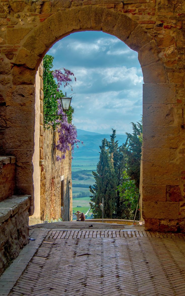 an open stone door leading to a scenic view over the hills and valleys in the distance