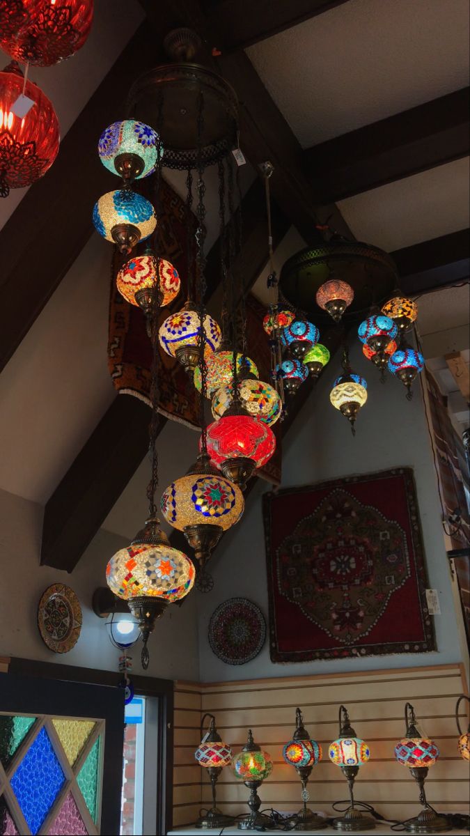 a chandelier hanging from the ceiling in a room with stained glass windows and lights