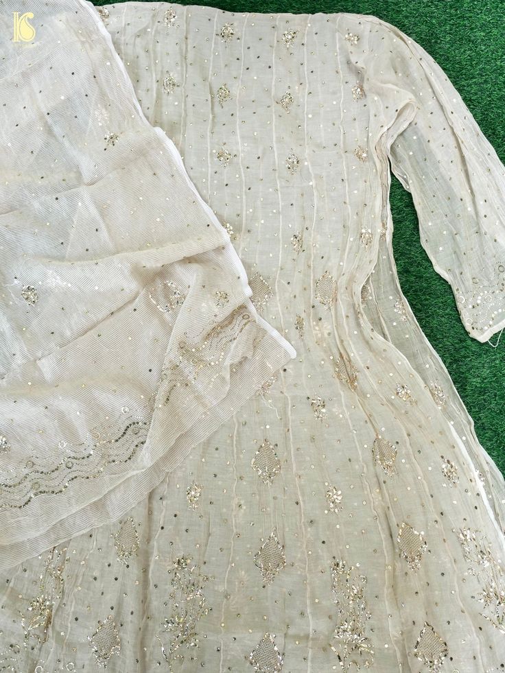 a white dress laying on top of a green carpet