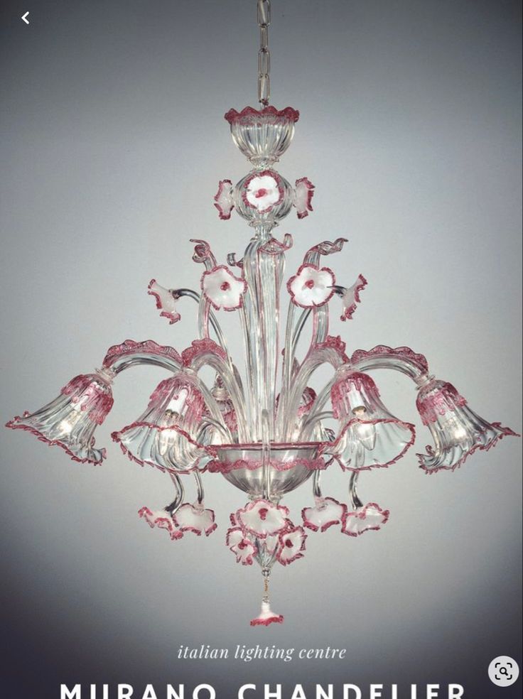 a pink chandelier hanging from the ceiling in front of a gray background with white flowers