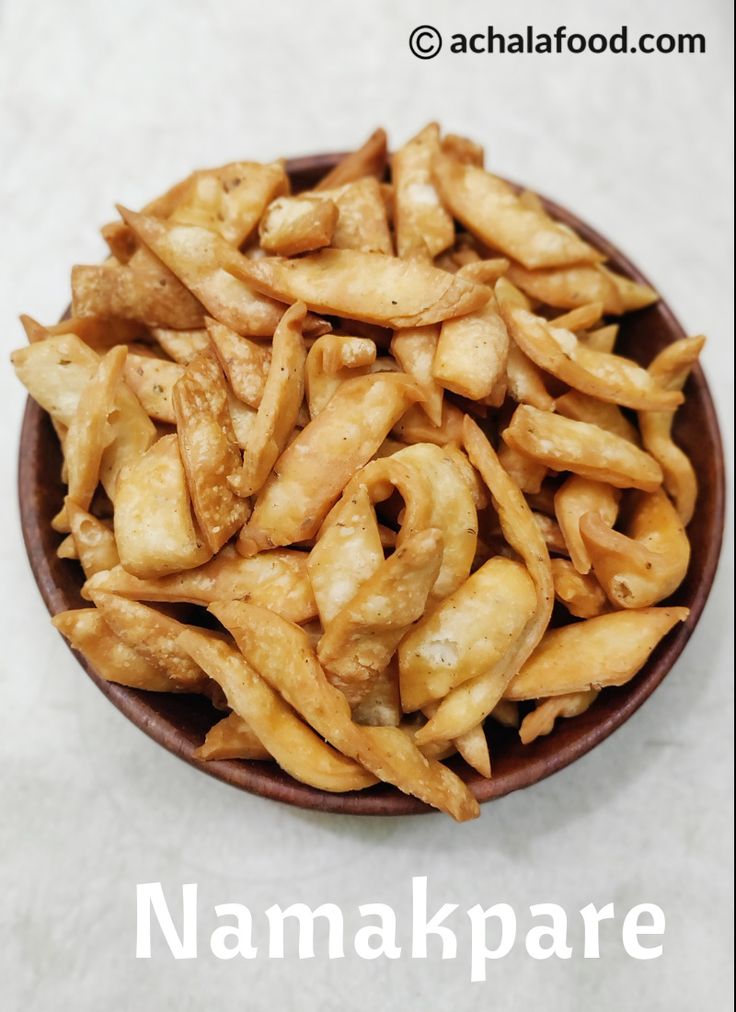 a wooden bowl filled with fried food on top of a white tablecloth next to the words namkapare