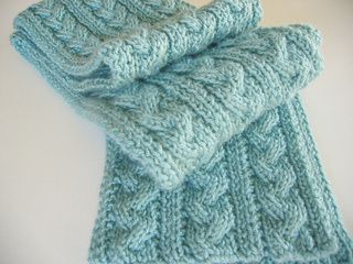 a blue knitted scarf laying on top of a white table