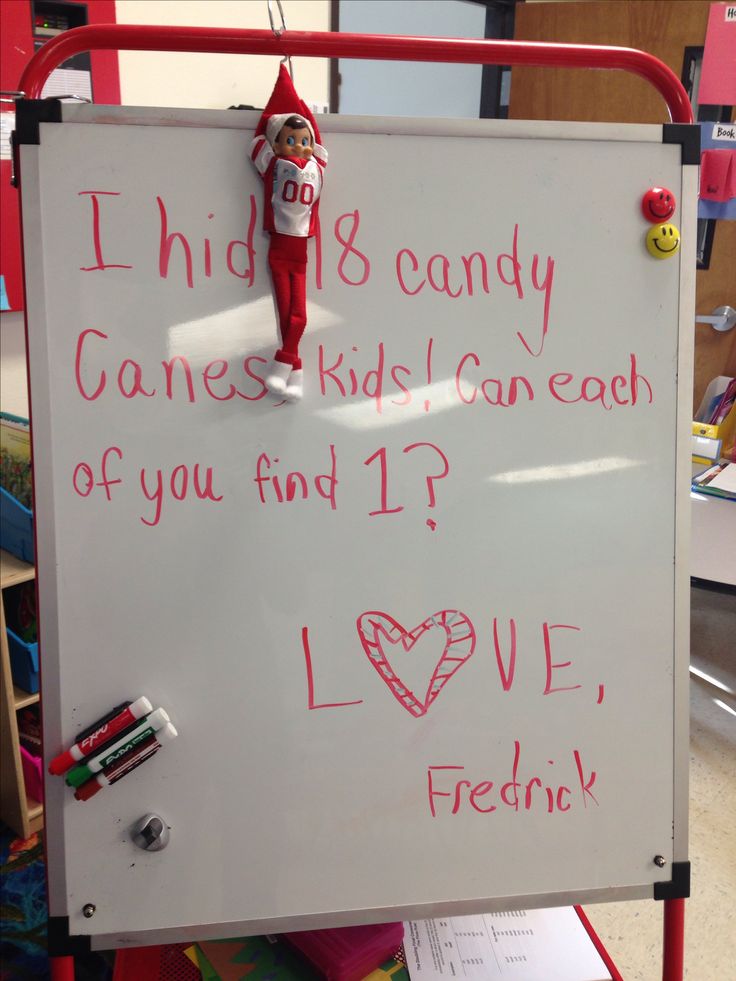 a white board with writing on it and an elf holding a candy cane