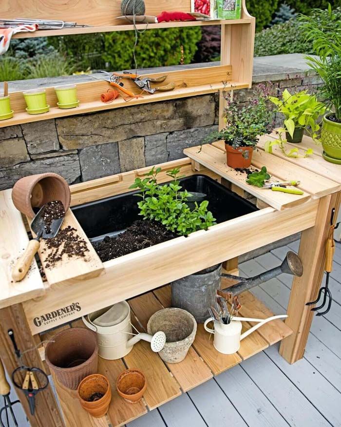 an outdoor garden with potted plants and gardening tools